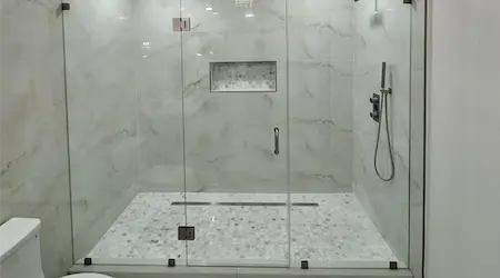 Dual custom frameless glass shower enclosure with black marble tile and matte black hardware — Glass Designer LLC Fort Myers