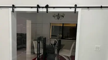 Frameless glass shower enclosure with dark subway tile and recessed niche installed by Glass Designer LLC in Naples FL